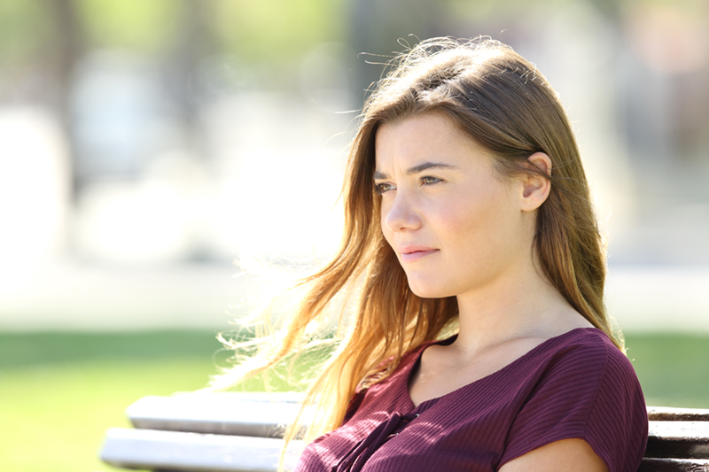 woman looking off to the side with a serious look on her face